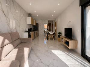 a living room with a couch and a dining room at Benidorm Center Playa Poniente in Benidorm