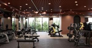 a gym with treadmills and machines in a room at Cortina North Luxury Studio in Voluntari