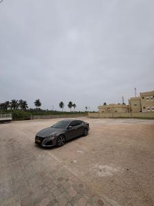 a black car parked in a parking lot at بنايه بيت الشب in Ţāqah