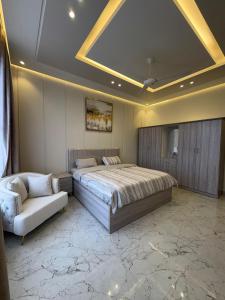 a bedroom with a large bed and a couch at بنايه بيت الشب in Ţāqah