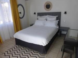 a bedroom with a large bed with white sheets and pillows at Hotel Castellamar in Sainte-Maxime