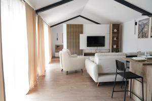 a living room with white furniture and a tv at Kostadinov Residence in Demir Kapija