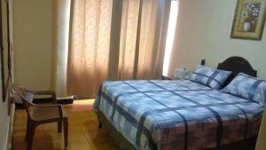 a bedroom with a bed and a chair in it at Hotel Terraza in San Pedro Sula