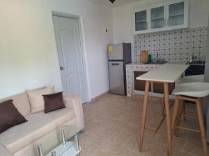 a living room with a couch and a kitchen at Acogedor Departamento Entero in Hornillo