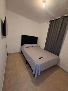a bedroom with a bed and a television in it at Acogedor Departamento Entero in Hornillo