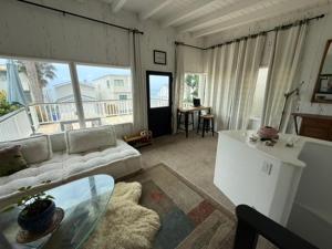 a living room with a couch and a table at Malibu Surf Cottage on Lechuza Beach in Malibu