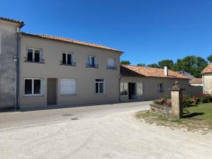 a large white building with a road in front of it at Le Pressoir de Marsac in Marsac