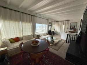 a living room with a couch and a table at Malibu Surf Cottage on Lechuza Beach in Malibu