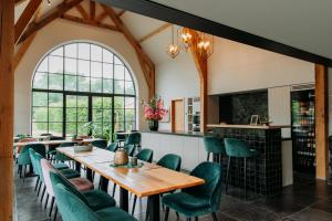a dining room with tables and chairs and a fireplace at Casa Cava B&B in Dendermonde