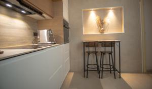 a kitchen with two bar stools next to a counter at Forrent malaga in Málaga