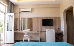 a bedroom with a bed and a tv and a chair at Elazığ Mavigöl Otel in Sivrice