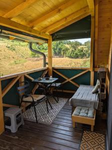a porch of a wooden cabin with a table and a bench at Prenoćište Lelić in Valjevo