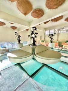 a lobby with a pool with chairs and plants at Rental Higueron Boutique Resort in Fuengirola
