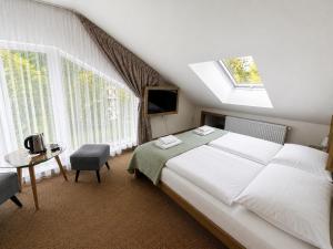 a bedroom with a bed and a table and windows at Aparthotel Belveder in Tatranská Lomnica