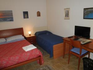 a bedroom with a bed and a desk with a computer at Don Milani in Matera