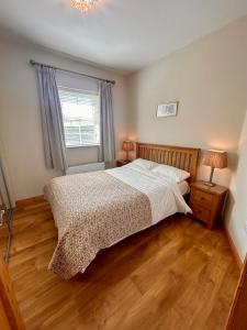 a bedroom with a bed and a window at Fairy Fort View, Lahinch in Carrowauff