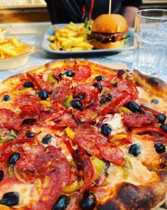 a pizza on a table with a hamburger and french fries at Connemara National Park Lodge in Letterfrack +12 photos