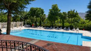 a large swimming pool with chairs and trees at Elazığ Mavigöl Otel in Sivrice