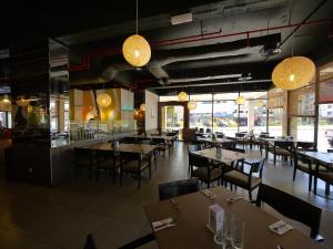 a dining room with tables and chairs and lights at Premier Hotel in Sibu
