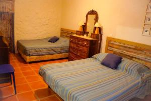 a bedroom with two beds and a dresser and a mirror at Au coeur de Leucate in Leucate