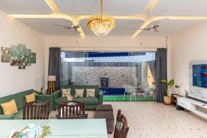 a living room with a couch and a table at Velmora Stay Premium Luxury Villa with Private Pool in Amritsar