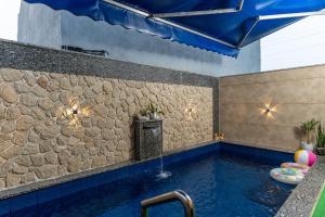 a swimming pool with a fountain and a stone wall at Velmora Stay Premium Luxury Villa with Private Pool in Amritsar