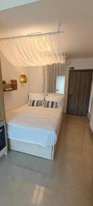a bedroom with a white bed with a canopy at VALEXX luxury studio in Perea