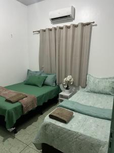 a room with two beds and a air conditioner at Apto garagem incluso in Marabá