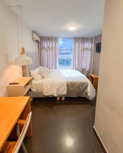 a small bedroom with a bed and a window at Hotel Centro in Cali