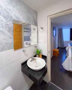 a bathroom with a sink and a mirror at Hotel Centro in Cali +2 photos