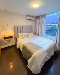 a bedroom with a large bed with a window at Hotel Centro in Cali