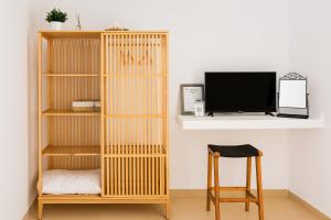 a wooden book shelf in a room with a tv at Schinos Salty Studio in Vathí
