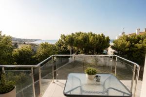 a glass table on a balcony with a view at Schinos Salty Studio in Vathí
