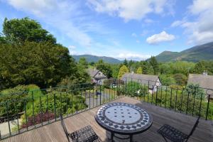 a patio with a table and chairs on a deck at Skiddaw Grove in Keswick