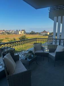 a patio with couches and chairs on a balcony at Calliopes by the sea boutique suites in Paralia Dionysiou