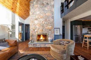 a living room with a large stone fireplace at The Bellows House - Views Deck Skiing in Fleischmanns