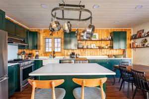 a kitchen with green cabinets and a table with chairs at The Bellows House - Views Deck Skiing in Fleischmanns