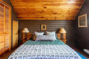 a bedroom with a large bed with two lamps at The Bellows House - Views Deck Skiing in Fleischmanns