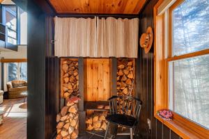 a room with a stack of fire wood and a chair at The Bellows House - Views Deck Skiing in Fleischmanns