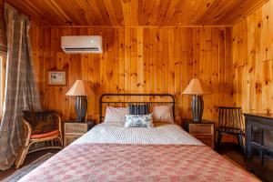 a bedroom with a bed in a wooden wall at The Bellows House - Views Deck Skiing in Fleischmanns +28 photos