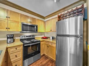 a kitchen with wooden cabinets and a stainless steel refrigerator at CS129 Copper Springs in Copper Mountain
