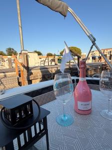 two wine glasses and a bottle on a table at bahati blue riviera in Mandelieu-La Napoule