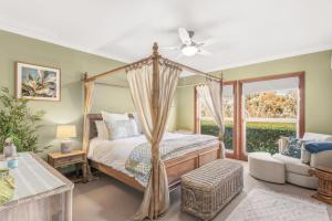 a bedroom with a canopy bed and a window at Three Acres, Barossa Valley in Williamstown +34 photos