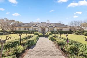 a large house with a brick walkway through a garden at Three Acres, Barossa Valley in Williamstown