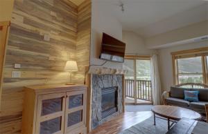 a living room with a fireplace and a tv at CS407 Copper Springs in Copper Mountain