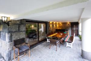 a patio with a table and chairs and a stone wall at Villa Eterna in Tarčin
