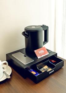 a coffee maker sitting on top of a table at Treal Hotels & Suites in Abeokuta