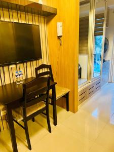 a dining room with a table and a television on a wall at Shell Residences Manila by PauL in Manila