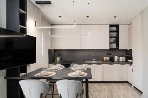 a kitchen with white cabinets and a table with chairs at Agathe Apartment in Ierapetra