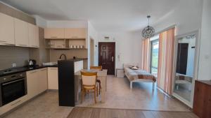a kitchen and living room with a table and chairs at Студио JASMIN in Tsarevo